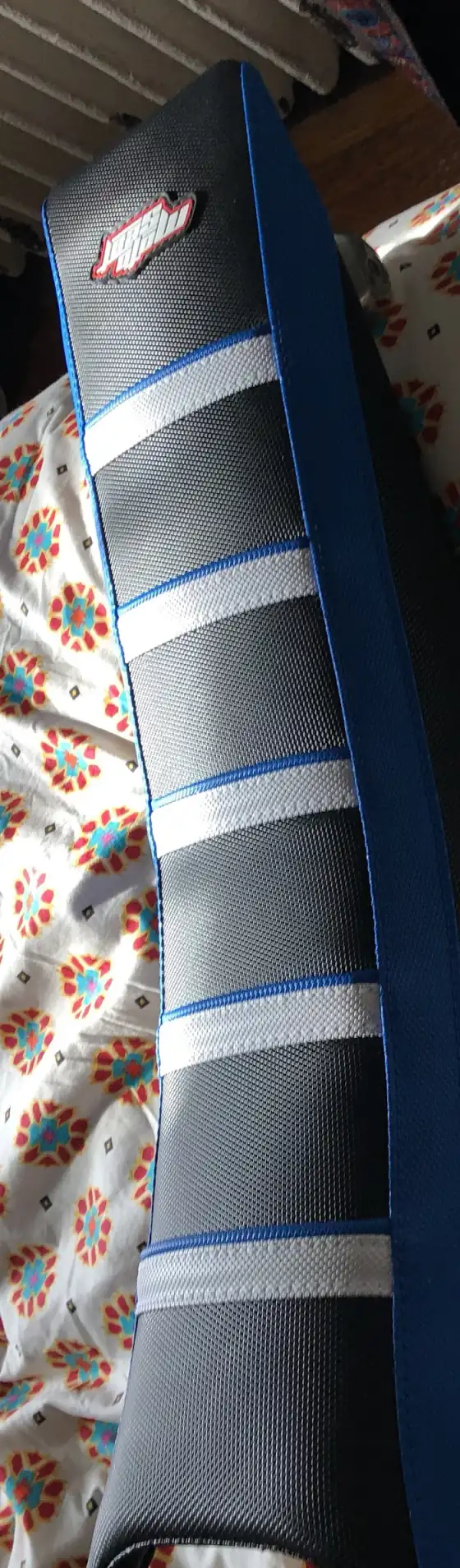 Reupholstered powersports motorcycle seat in a ribbed gripper cover